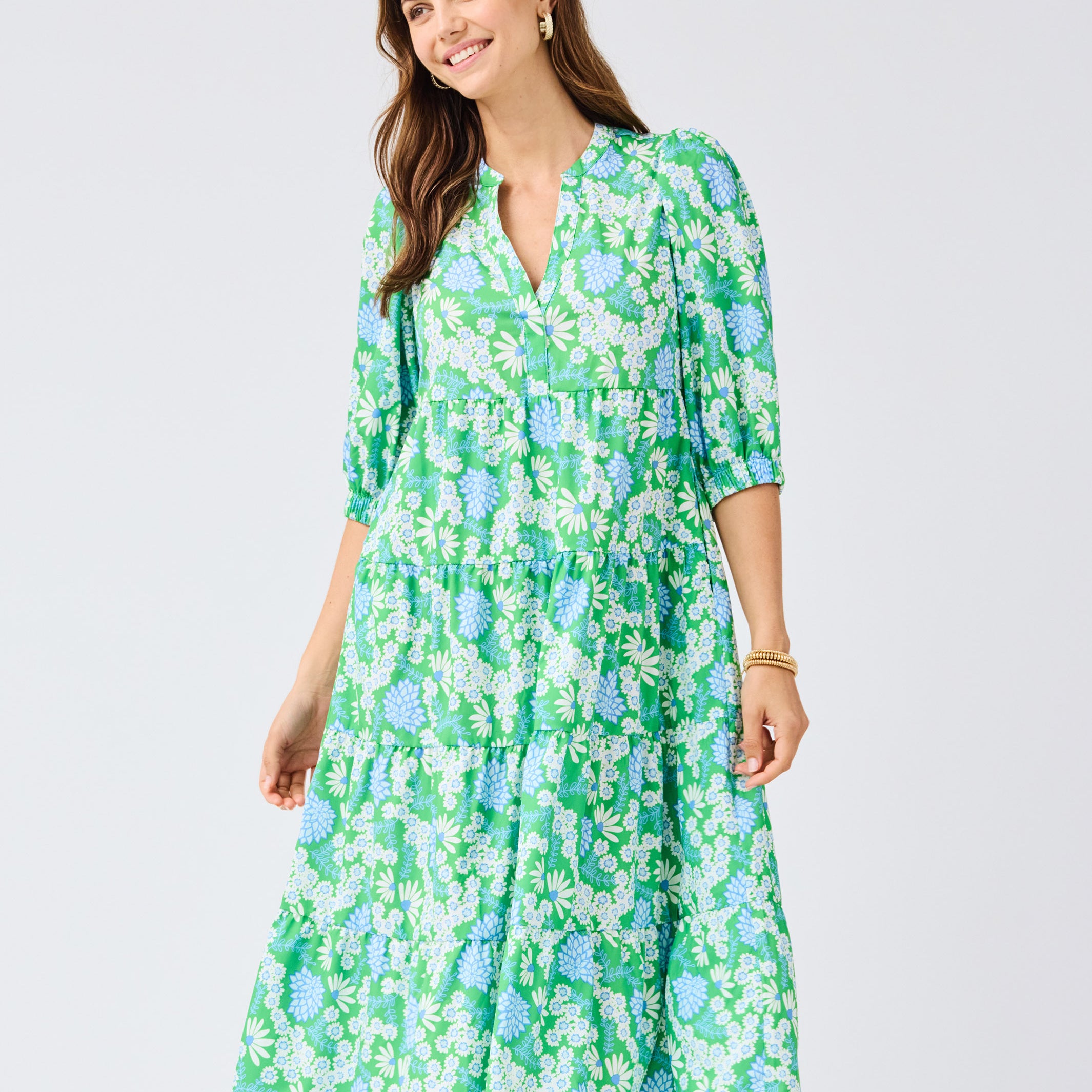 Woman wearing a green floral dress on a light gray background