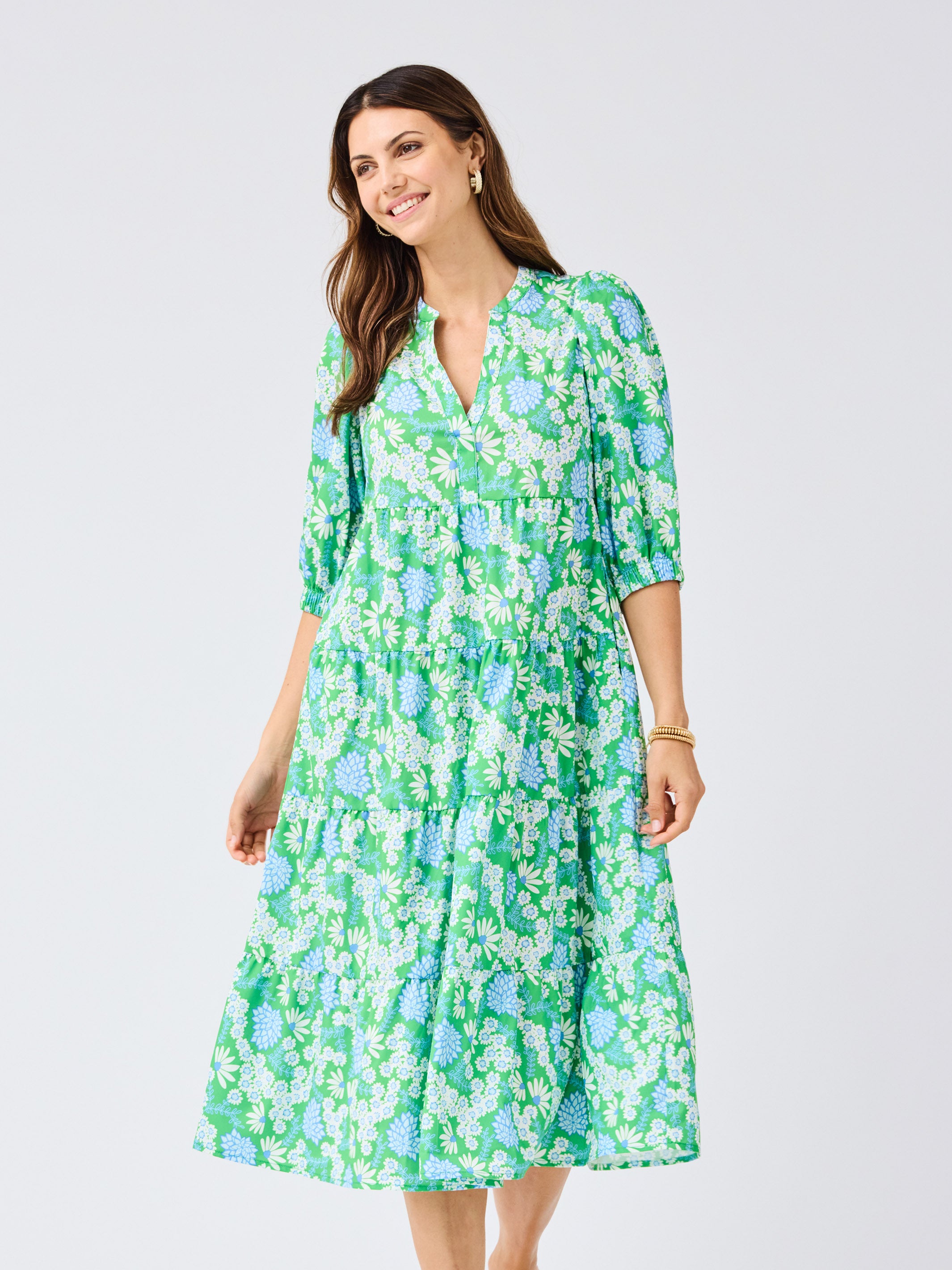 Woman wearing a green floral dress on a light gray background