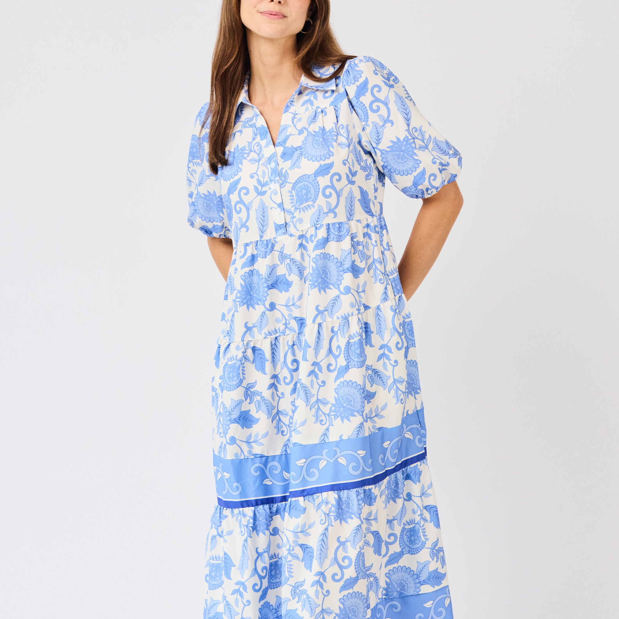 Woman wearing a blue floral dress on a white background