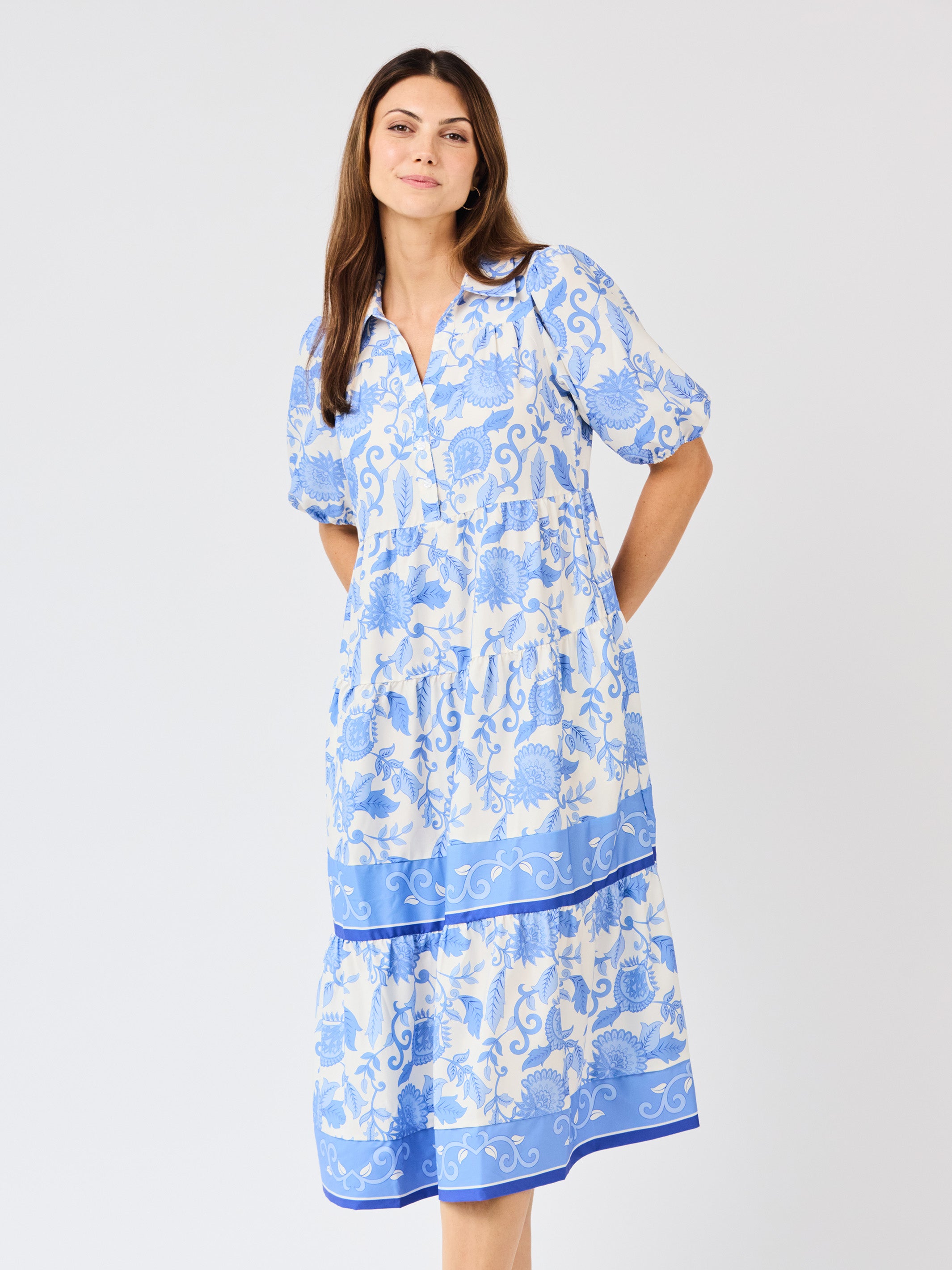 Woman wearing a blue floral dress on a white background