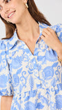 Woman wearing a blue floral dress against a white background