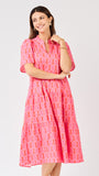 Woman wearing a pink patterned dress on a white background