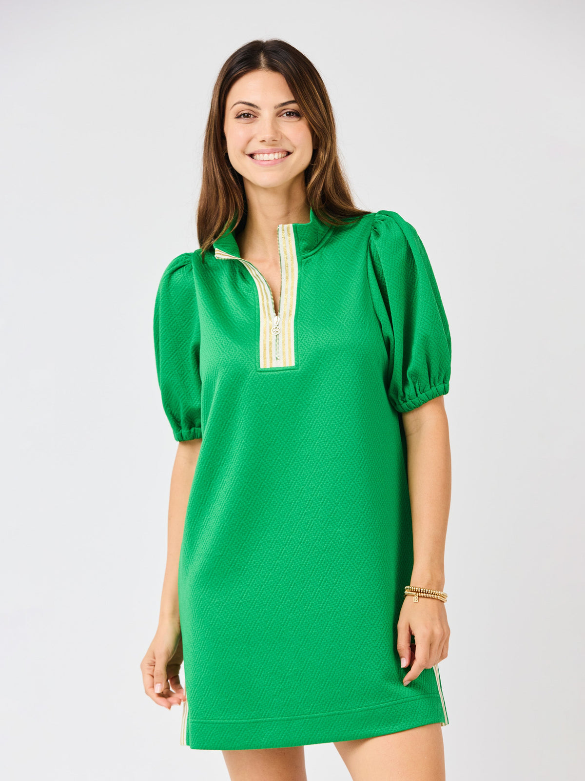 Woman wearing a green dress with short sleeves on a white background
