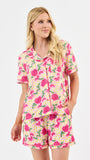 Woman wearing a pink floral pajama set on a white background