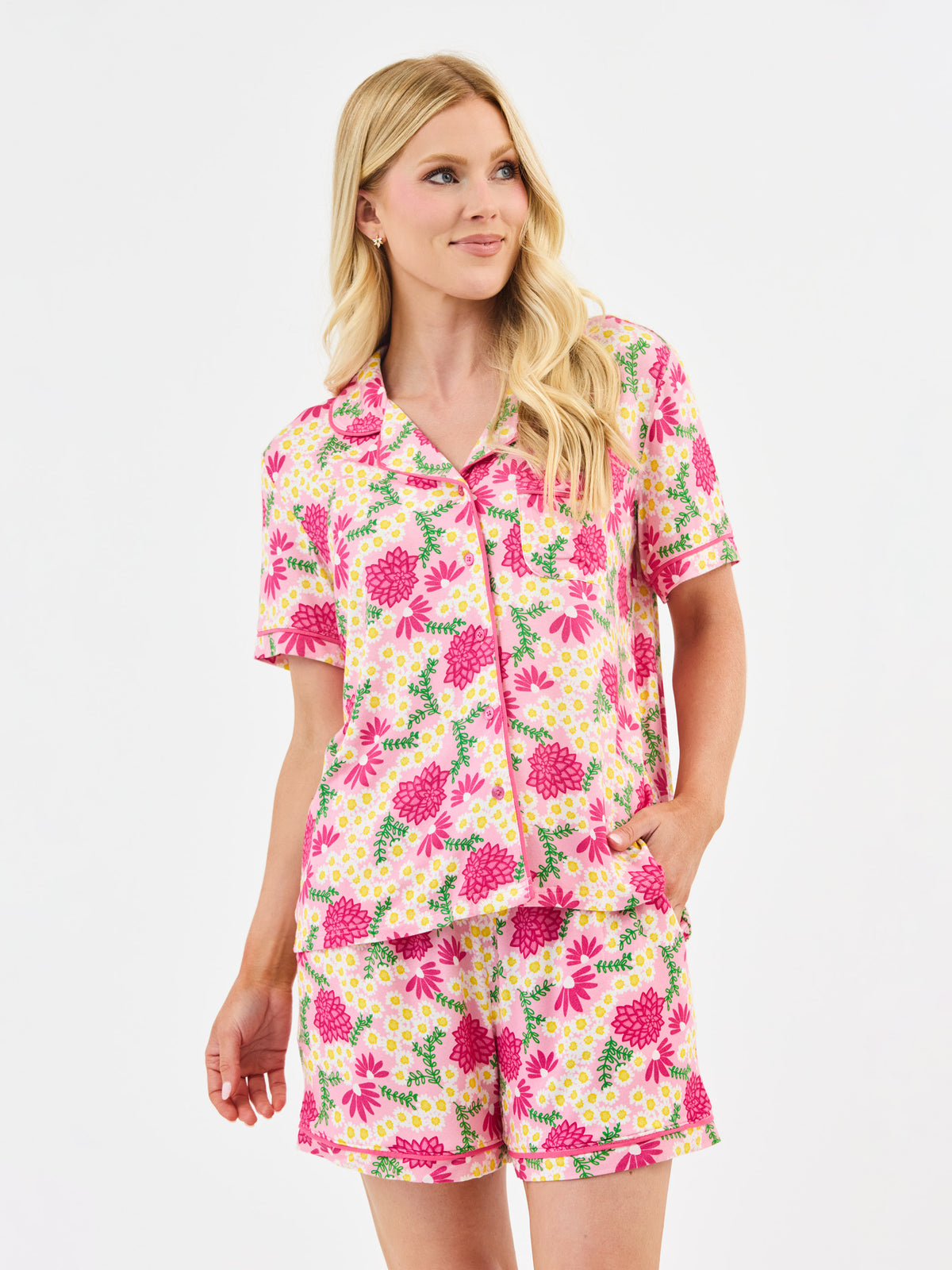 Woman wearing a pink floral pajama set on a white background