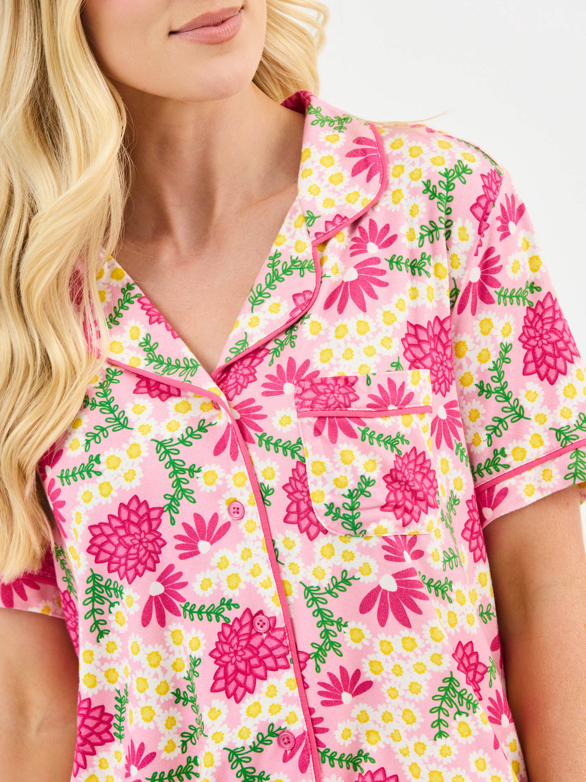 Woman wearing a pink floral patterned shirt with a white background