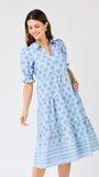 Woman wearing a blue patterned dress on a white background