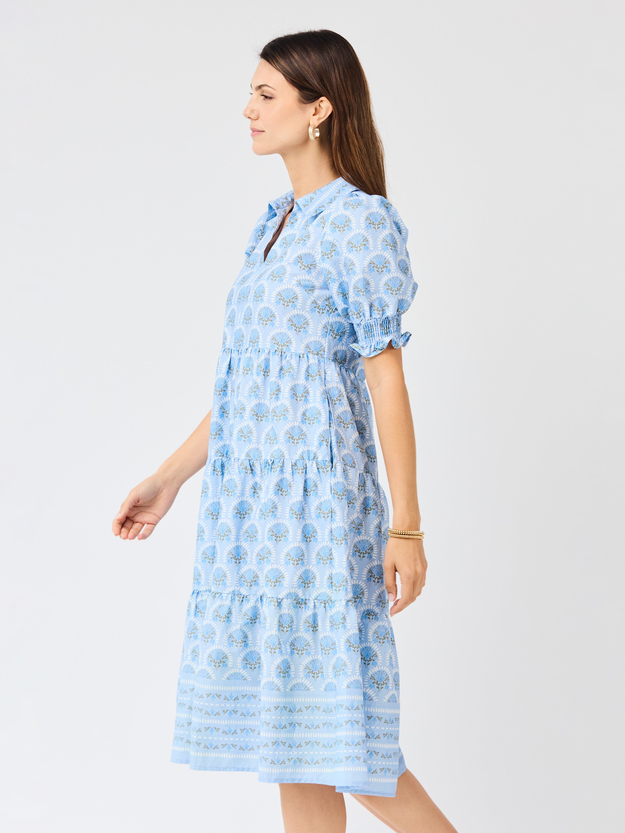 Woman wearing a blue patterned dress on a white background