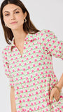 Woman wearing a floral dress with pink flowers on a white background