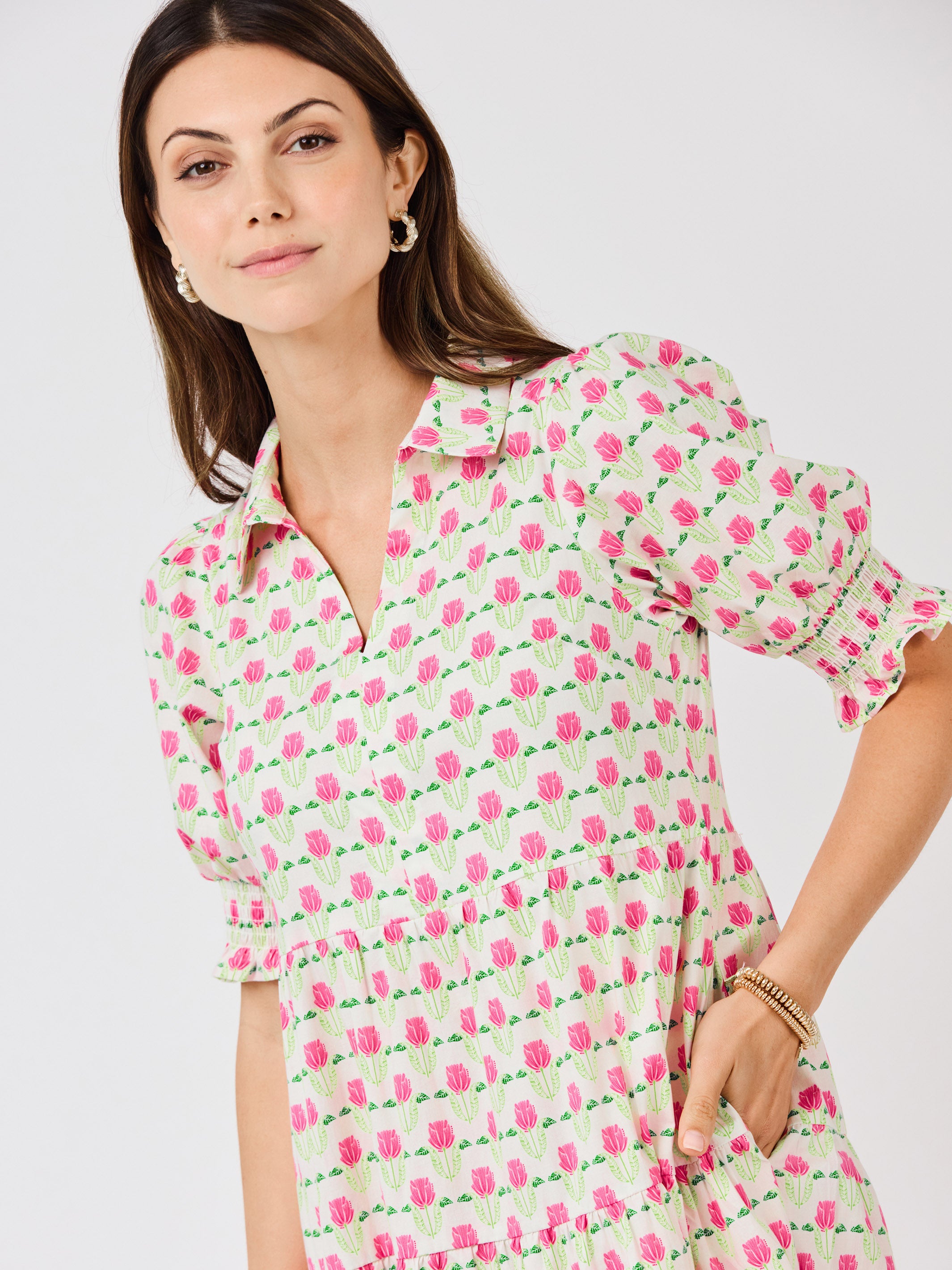 Woman wearing a floral dress with pink flowers on a white background