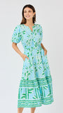 Woman wearing a blue and green patterned dress on a white background