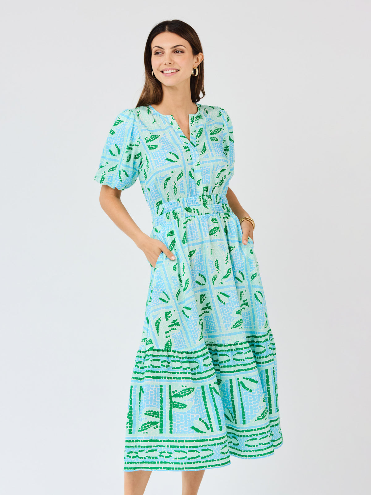 Woman wearing a blue and green patterned dress on a white background