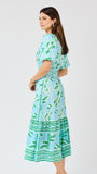 Woman wearing a blue and green patterned dress on a white background