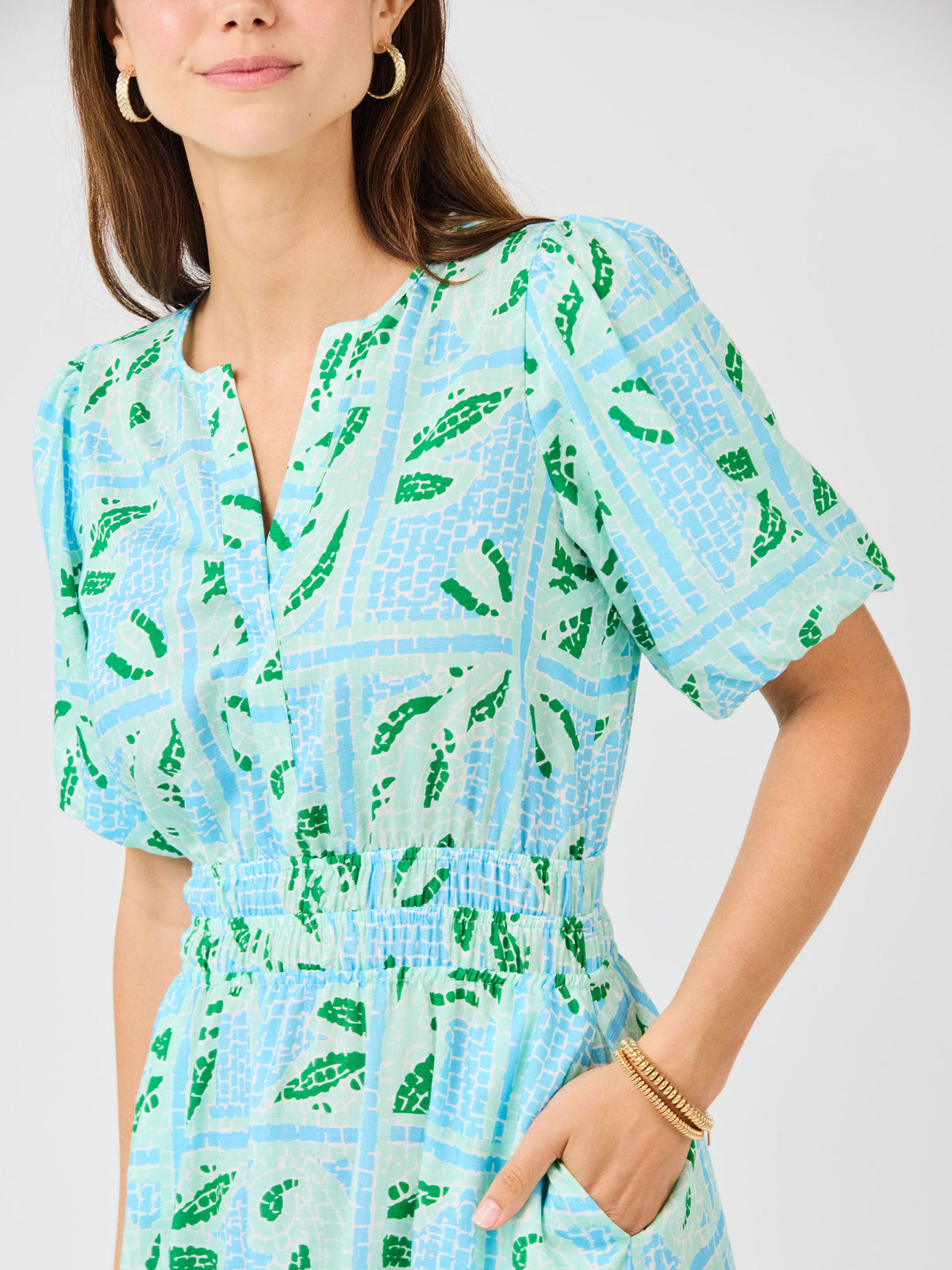 Woman wearing a blue and green patterned dress on a white background