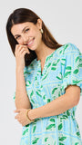 Woman wearing a blue and green patterned dress on a white background