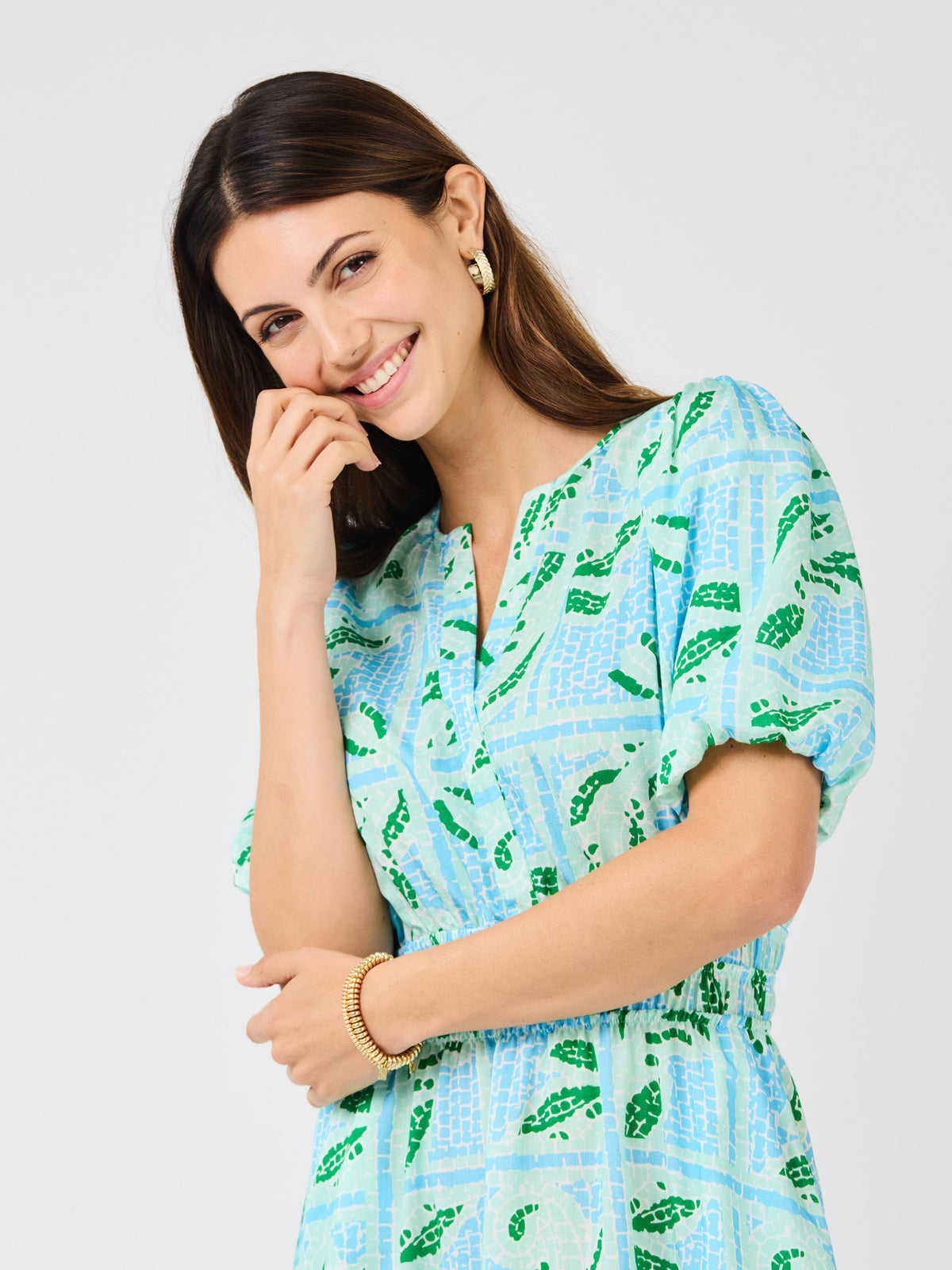 Woman wearing a blue and green patterned dress on a white background