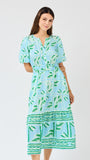 Woman wearing a blue and green patterned dress on a white background