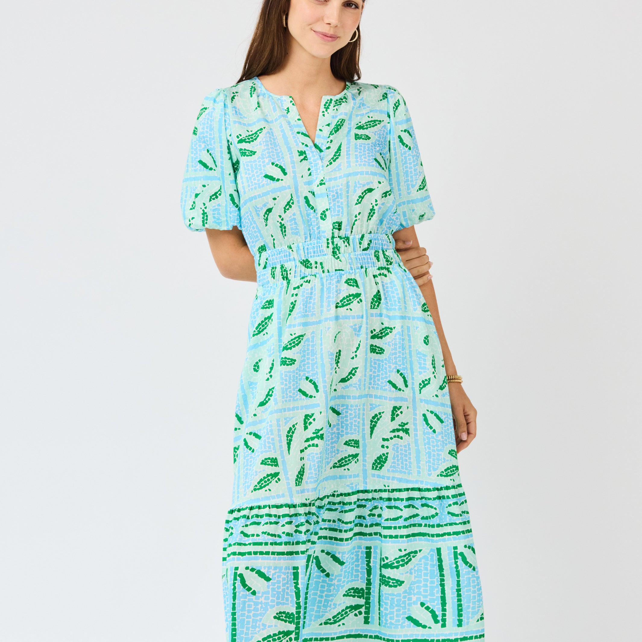 Woman wearing a blue and green patterned dress on a white background