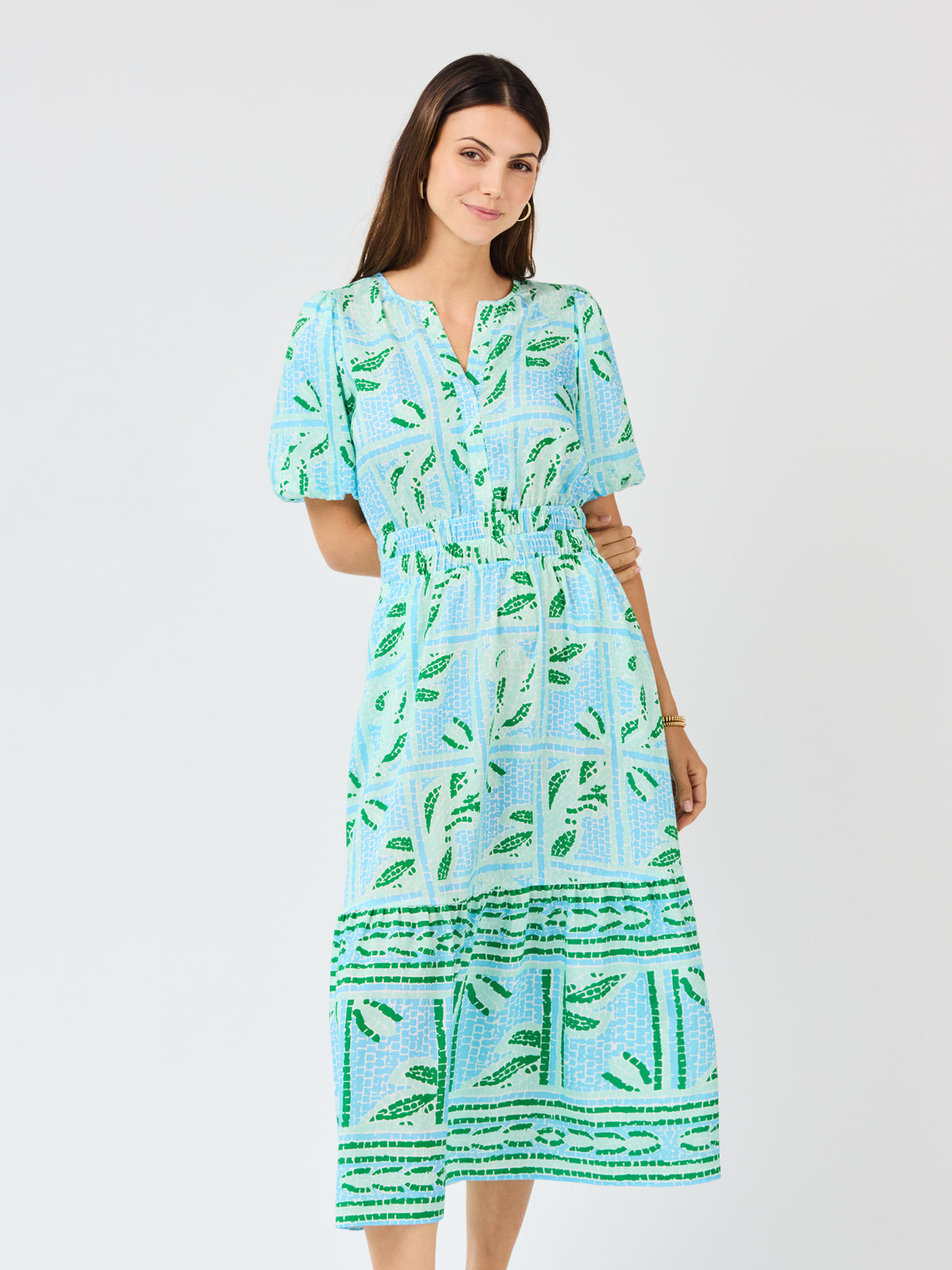 Woman wearing a blue and green patterned dress on a white background