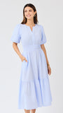 Woman wearing a light blue seersucker striped dress on a white background