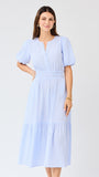 Woman wearing a light blue seersucker midi dress with puff sleeves a white background