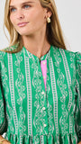 Woman wearing a green patterned dress with a white background