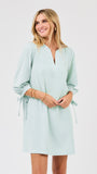 Woman wearing a light green striped dress on a white background