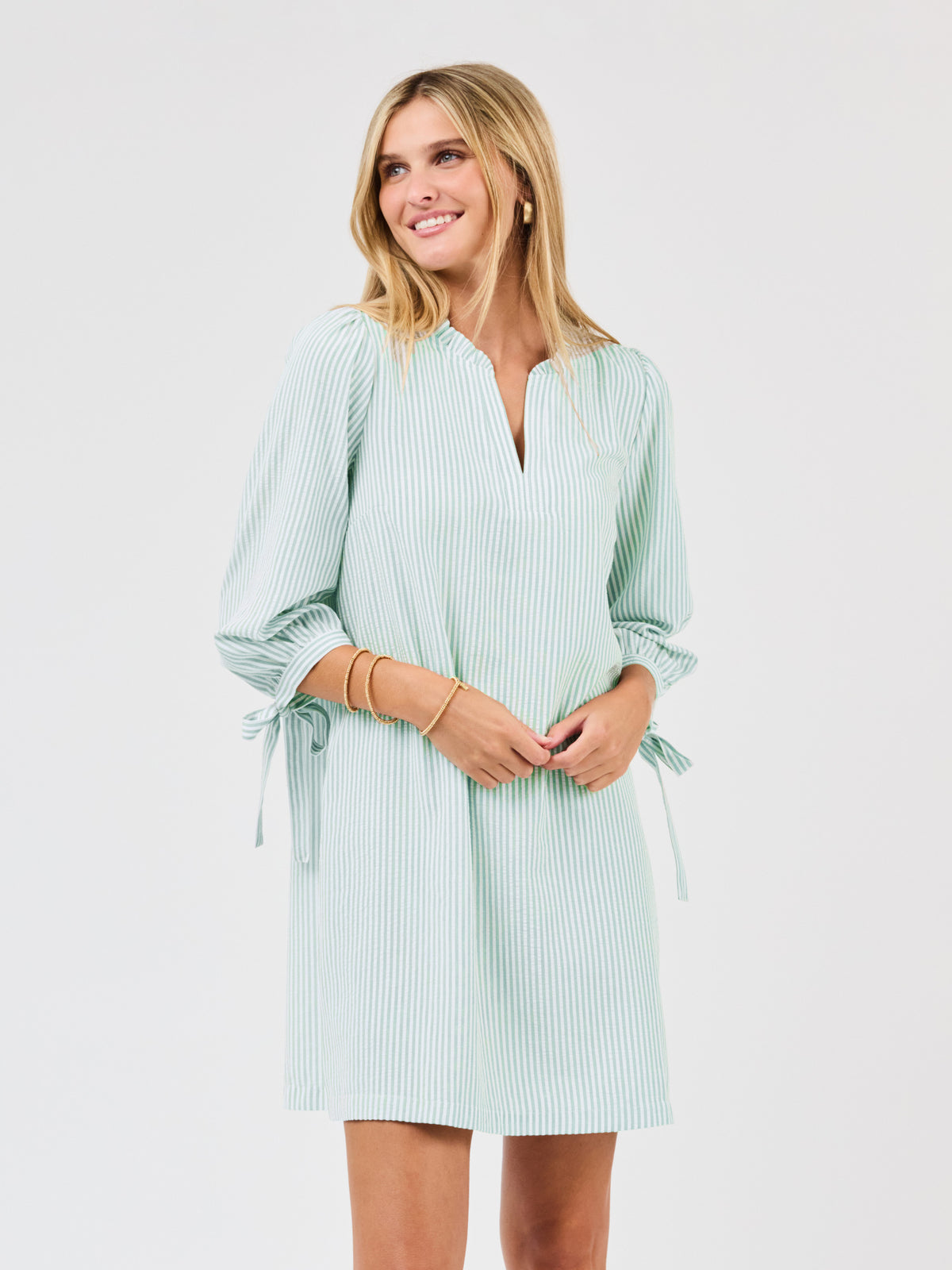 Woman wearing a light green striped dress on a white background