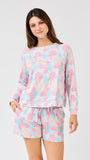Woman wearing a pastel floral pajama set on a white background
