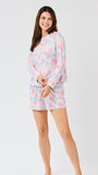 Woman wearing a pastel floral pajama set on a white background