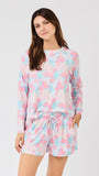 Woman wearing a pastel floral pajama set on a white background
