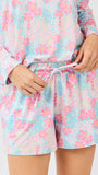 Woman wearing a pastel floral pajama set on a white background