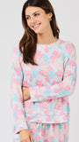 Woman wearing a pastel floral pajama set on a white background