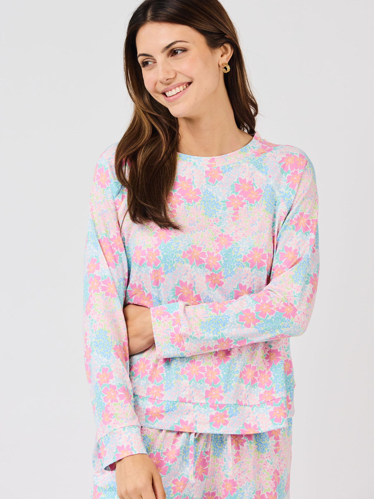 Woman wearing a pastel floral pajama set on a white background