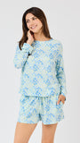 Woman wearing a blue floral pajama set on a white background
