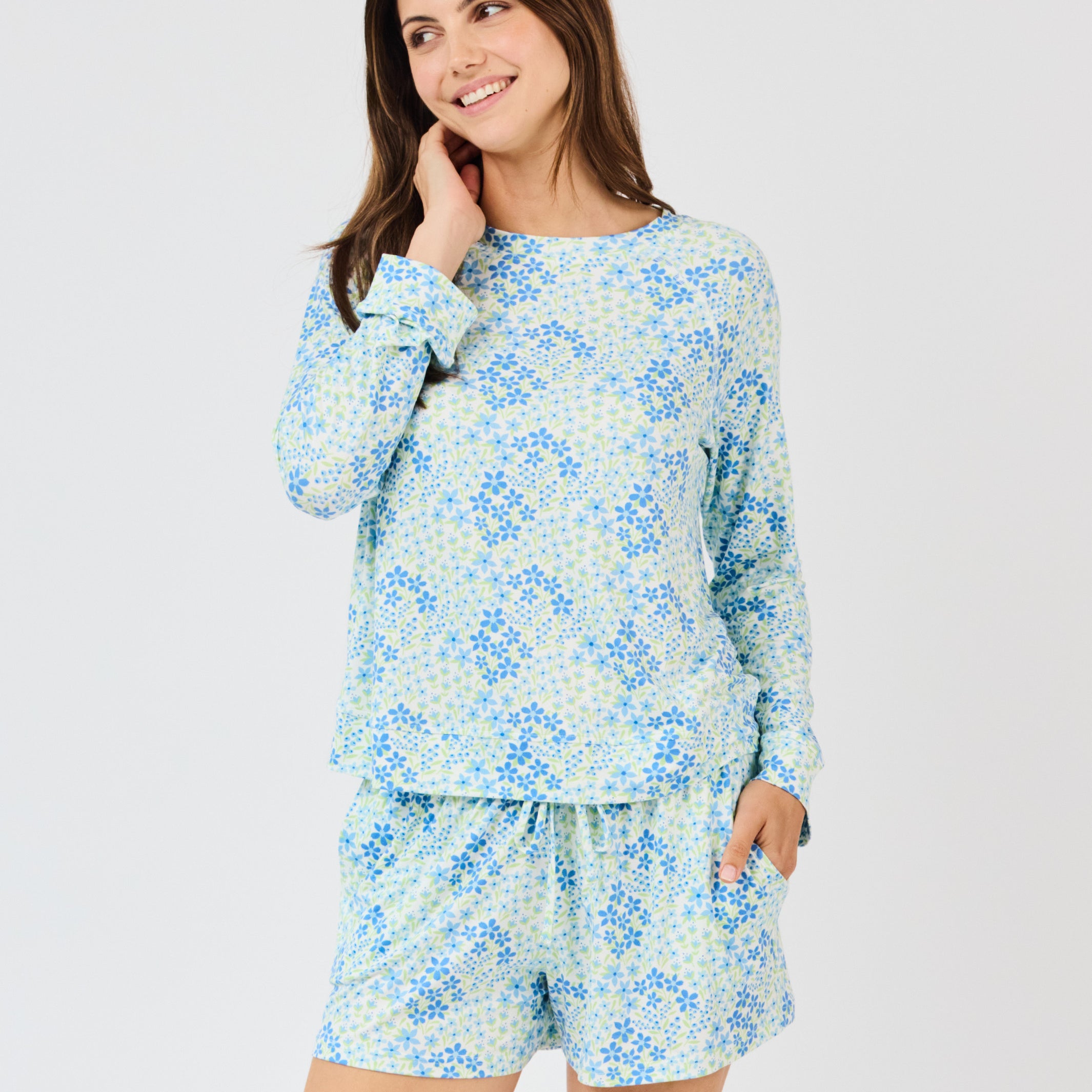 Woman wearing a blue floral pajama set on a white background