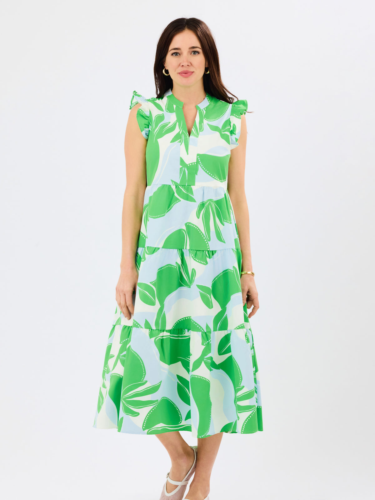 Woman wearing a green and white leaf-patterned dress on a white background