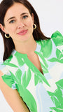 Woman wearing a green and white patterned dress on a plain background