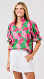 Woman wearing a green floral blouse with pink flowers on a white background