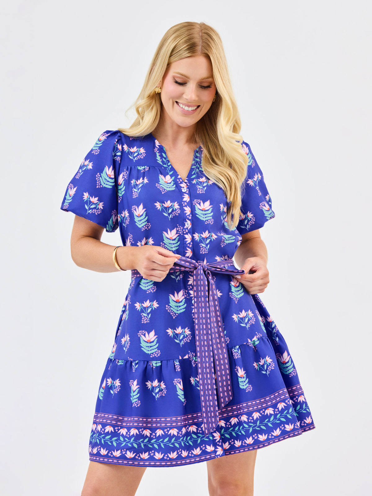 Woman wearing a blue dress with floral pattern on a white background