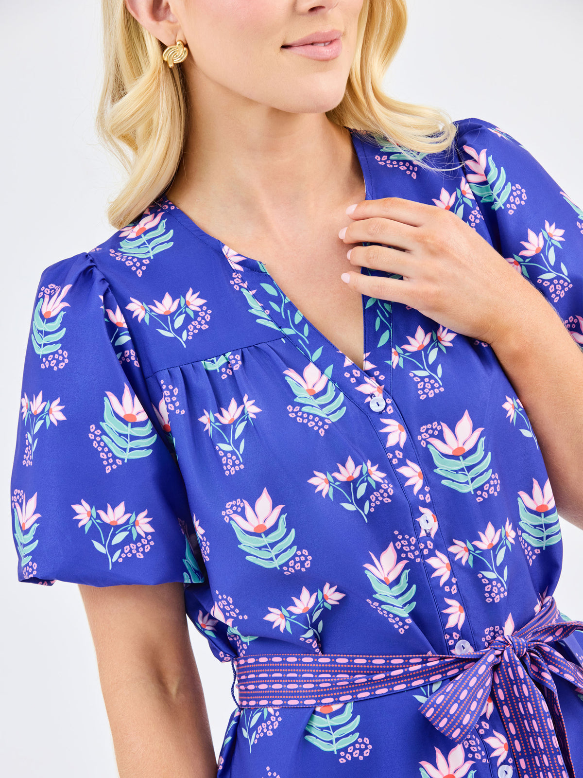 Woman wearing a blue floral dress with a white background