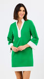 Woman wearing a green dress with white trim on a white background