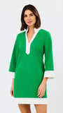 Woman wearing a green dress with white trim on a white background