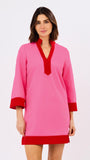 Woman wearing a pink dress with red accents on a white background