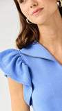 Woman wearing a blue dress with ruffled sleeves on a white background