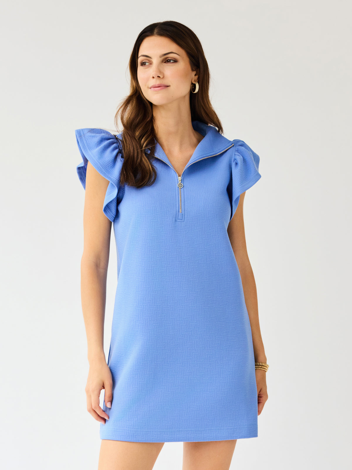 Woman wearing a blue dress with ruffled sleeves on a white background
