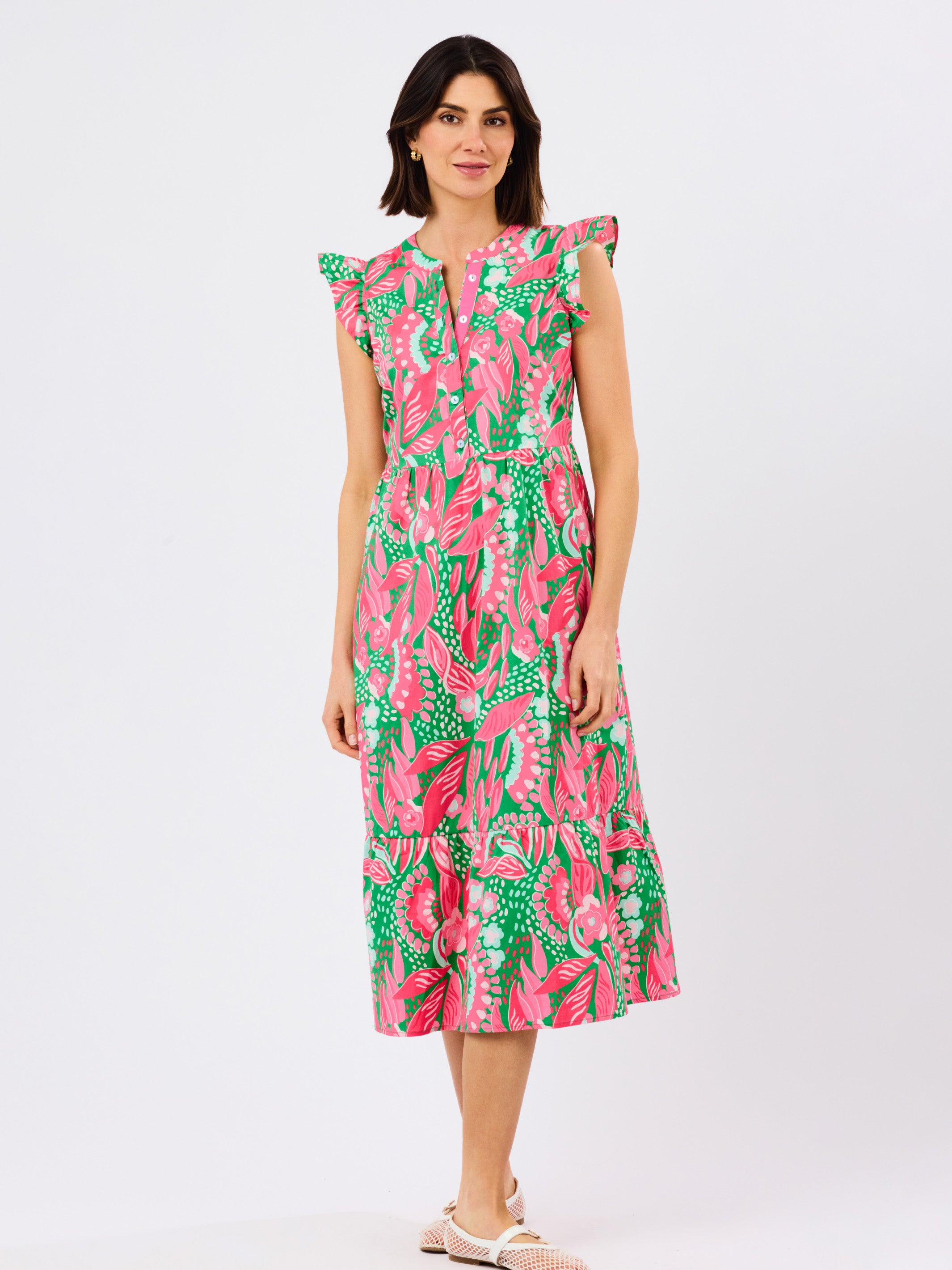 Woman wearing a colorful dress with a floral pattern on a white background