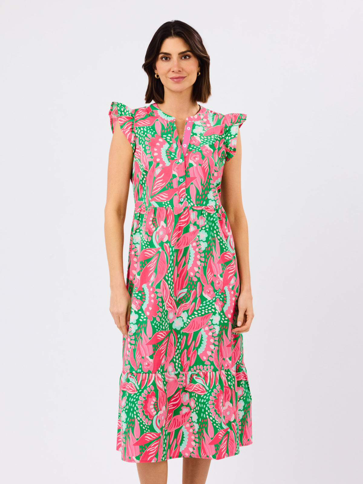 Woman wearing a pink and green floral dress on a white background
