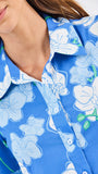Close-up of a blue floral patterned dress with a woman wearing it.