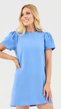 Woman wearing a light blue dress against a white background